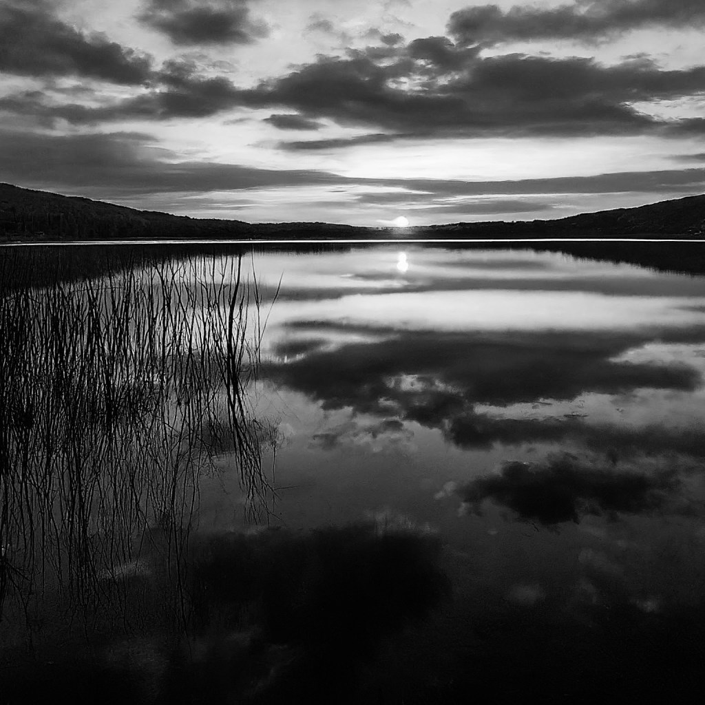 AI generated image of a sunset over a water body